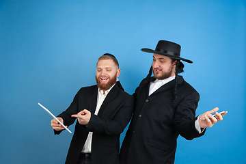 Image showing Portrait of a young orthodox jewish men isolated on blue studio background, meeting the Passover