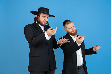 Image showing Portrait of a young orthodox jewish men isolated on blue studio background, meeting the Passover