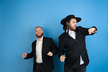 Image showing Portrait of a young orthodox jewish men isolated on blue studio background, meeting the Passover