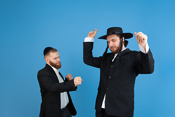 Image showing Portrait of a young orthodox jewish men isolated on blue studio background, meeting the Passover