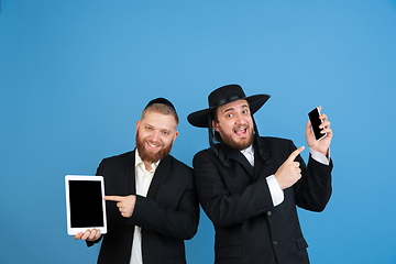 Image showing Portrait of a young orthodox jewish men isolated on blue studio background, meeting the Passover, winners