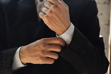 Image showing Close up of caucasian male hands, wearing classic black jacket