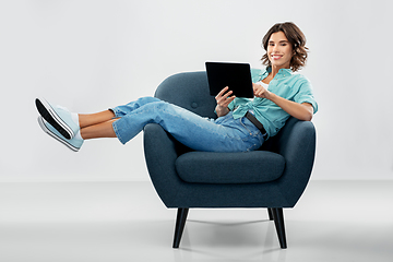 Image showing happy woman with tablet pc sitting in armchair