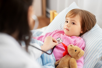 Image showing doctor with stethoscope and sick girl in bed