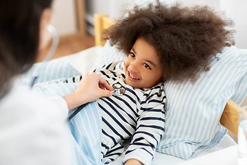 Image showing doctor with stethoscope and sick girl in bed