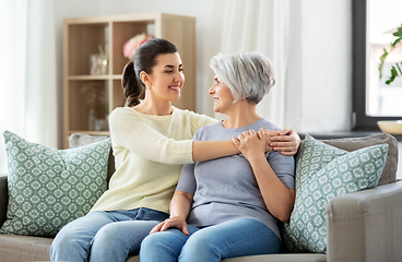 Image showing senior mother with adult daughter hugging at home