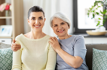 Image showing senior mother with adult daughter hugging at home