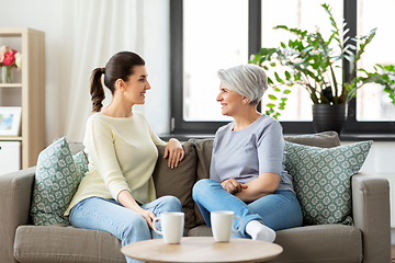 Image showing senior mother with adult daughter talking at home