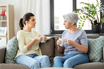 Image showing senior mother and adult daughter drinking coffee