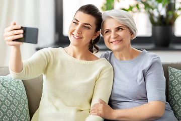 Image showing senior mother with daughter taking selfie at home