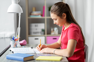 Image showing student girl with ruler drawing line in notebook