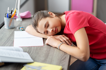 Image showing tired student girl sleeping on table at home