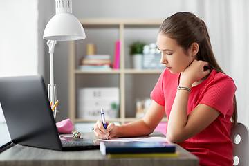 Image showing teenage student girl writing to notebook at home