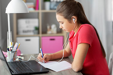 Image showing student girl in earphones learning at home