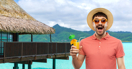 Image showing happy man in straw hat with juice on beach