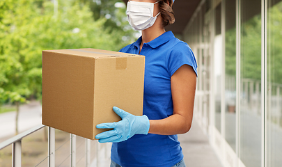 Image showing delivery woman in face mask holding parcel box