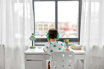 Image showing boy in headphones with textbook learning at home