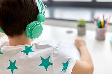 Image showing boy in headphones with textbook learning at home