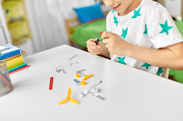 Image showing happy little boy playing with airplane toy at home