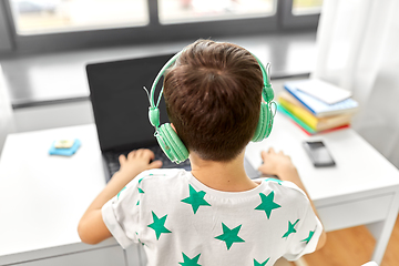 Image showing boy in headphones with laptop computer at home