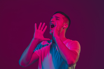 Image showing Caucasian man\'s portrait isolated on pink-purple studio background in neon light