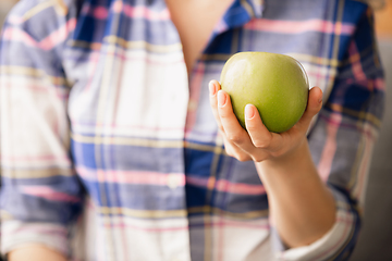 Image showing Close up of female hand holding green apple, healthy food, fruits