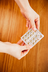 Image showing Coronavirus. Novel coronavirus 2019-nCoV , COVID-29, hands of a woman holding pack of pills