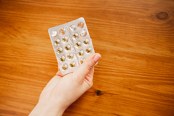 Image showing Coronavirus. Novel coronavirus 2019-nCoV , COVID-29, hands of a woman holding bunch of pills packs