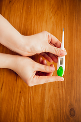 Image showing Coronavirus. Novel coronavirus 2019-nCoV , COVID-29, hands of a woman holding thermometer