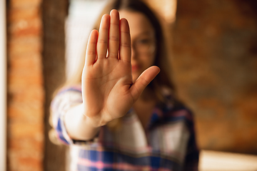Image showing Close up view of young woman making stop gesture with her hand. Cropped isolated portrait