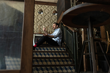 Image showing Public institutions closed due to COVID-19 or Coronavirus outbreak lockdown, stressed owner of small business alone in his cafe, restaurant, bar