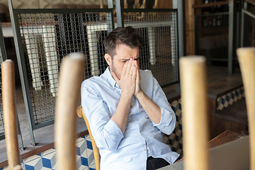 Image showing Public institutions closed due to COVID-19 or Coronavirus outbreak lockdown, stressed owner of small business alone in his cafe, restaurant, bar, shocked and despair