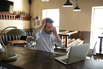 Image showing Restaurant, cafe, bar closed due to COVID-19 or Coronavirus outbreak lockdown, stressed owner of small business trying to find solution