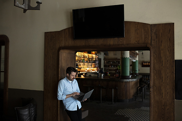 Image showing Public institutions closed due to COVID-19 or Coronavirus outbreak lockdown, stressed owner of small business alone in his cafe, looking for solution