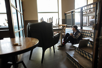 Image showing Public institutions closed due to COVID-19 or Coronavirus outbreak lockdown, stressed owner of small business alone in his cafe, restaurant, bar