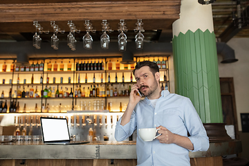 Image showing Public institutions closed due to COVID-19 or Coronavirus outbreak lockdown, stressed owner of small business alone in his cafe, restaurant, bar