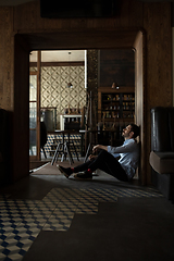 Image showing Public institutions closed due to COVID-19 or Coronavirus outbreak lockdown, stressed owner of small business alone in his cafe, despair lying down the floor