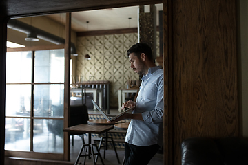 Image showing Public institutions closed due to COVID-19 or Coronavirus outbreak lockdown, stressed owner of small business alone in his cafe, looking for solution