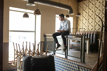 Image showing Public institutions closed due to COVID-19 or Coronavirus outbreak lockdown, stressed owner of small business alone in his cafe, restaurant, bar