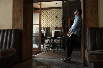 Image showing Public institutions closed due to COVID-19 or Coronavirus outbreak lockdown, stressed owner of small business alone in his cafe, despair