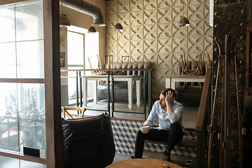 Image showing Public institutions closed due to COVID-19 or Coronavirus outbreak lockdown, stressed owner of small business alone in his cafe, despair