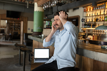 Image showing Restaurant, cafe, bar closed due to COVID-19 or Coronavirus outbreak lockdown, stressed owner of small business trying to find solution