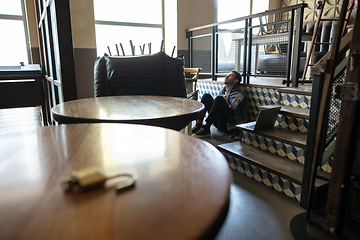 Image showing Public institutions closed due to COVID-19 or Coronavirus outbreak lockdown, stressed owner of small business alone in his cafe, restaurant, bar