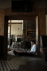 Image showing Public institutions closed due to COVID-19 or Coronavirus outbreak lockdown, stressed owner of small business alone in his cafe, despair lying down the floor