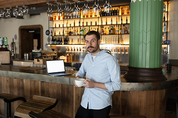 Image showing Public institutions closed due to COVID-19 or Coronavirus outbreak lockdown, stressed owner of small business alone in his cafe, restaurant, bar