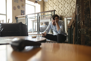 Image showing Public institutions closed due to COVID-19 or Coronavirus outbreak lockdown, stressed owner of small business alone in his cafe, despair