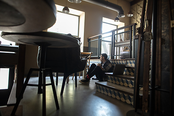 Image showing Public institutions closed due to COVID-19 or Coronavirus outbreak lockdown, stressed owner of small business alone in his cafe, restaurant, bar