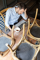 Image showing Public institutions closed due to COVID-19 or Coronavirus outbreak lockdown, stressed owner of small business alone in his cafe, restaurant, bar, shocked and despair