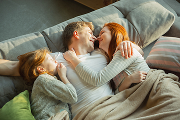 Image showing Family spending nice time together at home, looks happy and cheerful, lying down together