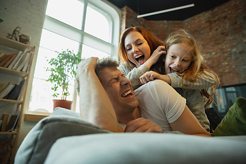 Image showing Family spending nice time together at home, looks happy and cheerful, lying down together